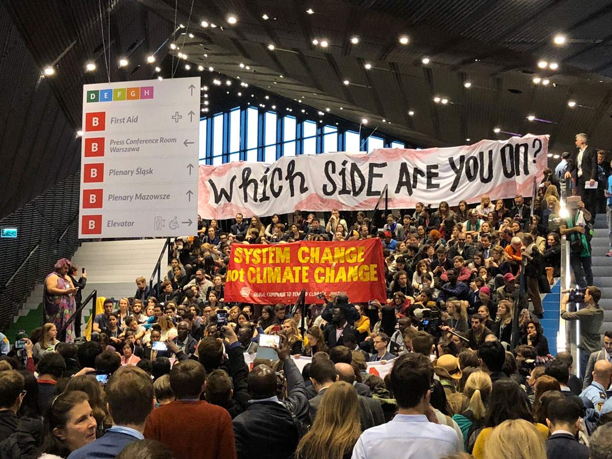 Protesters holding signs at COP24